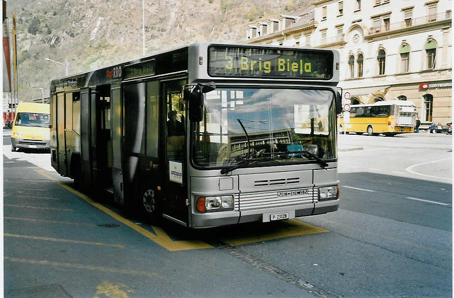 (052'932) - PTT-Regie - P 23'028 - Neoplan (ex Zerzuben, Visp-Eyholz Nr. 54) am 18. April 2002 beim Bahnhof Brig