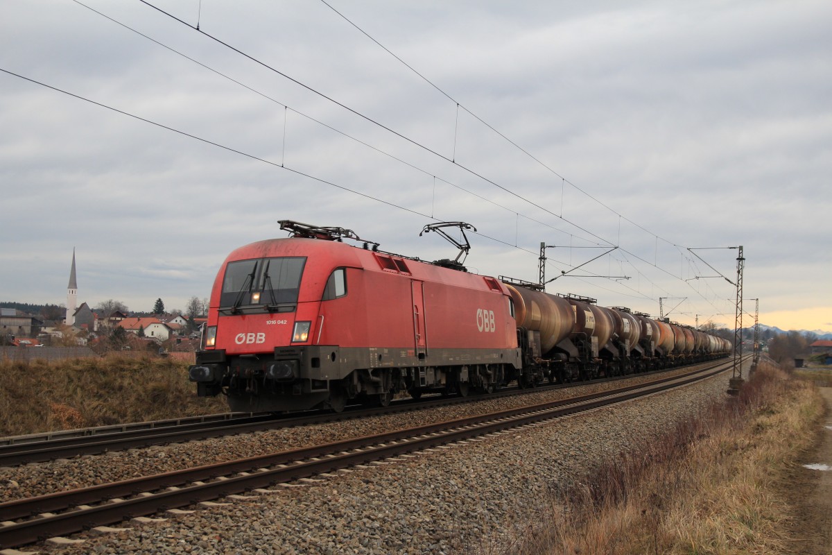 1016 042-2 fhrt mit einem Kesselzug am 4. Januar 2014 bei Ostermnchen in Richtung Mnchen.